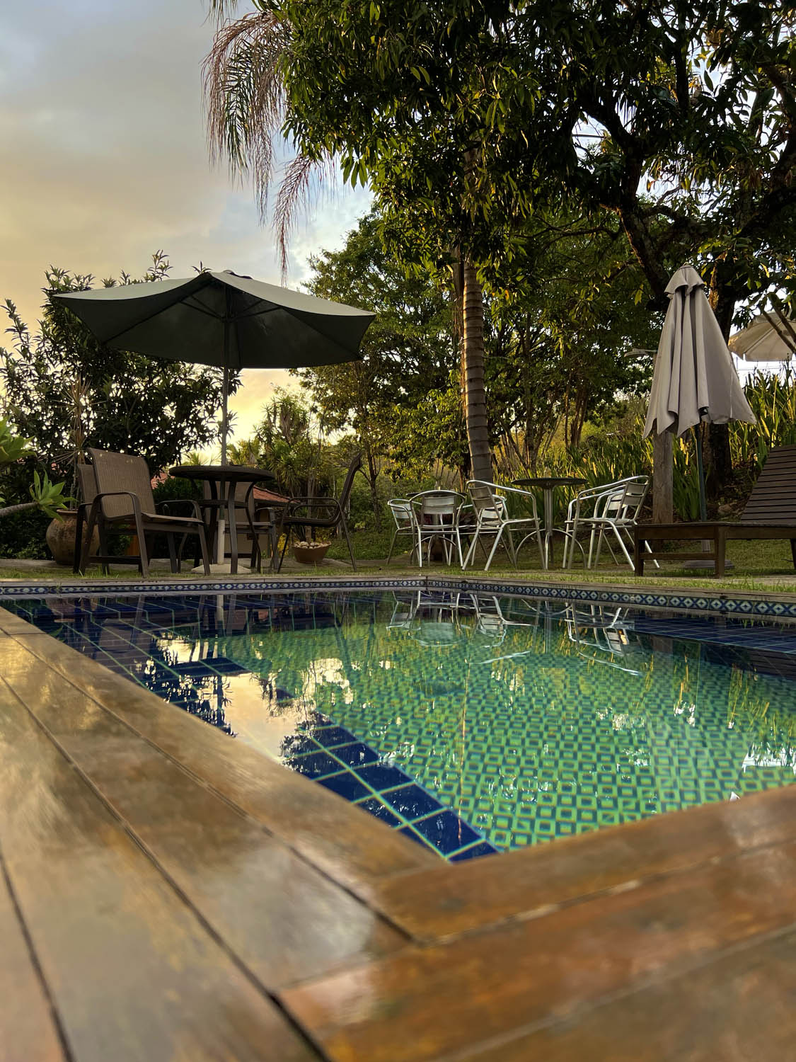 The inn's pool at dusk, surrounded by garden and trees