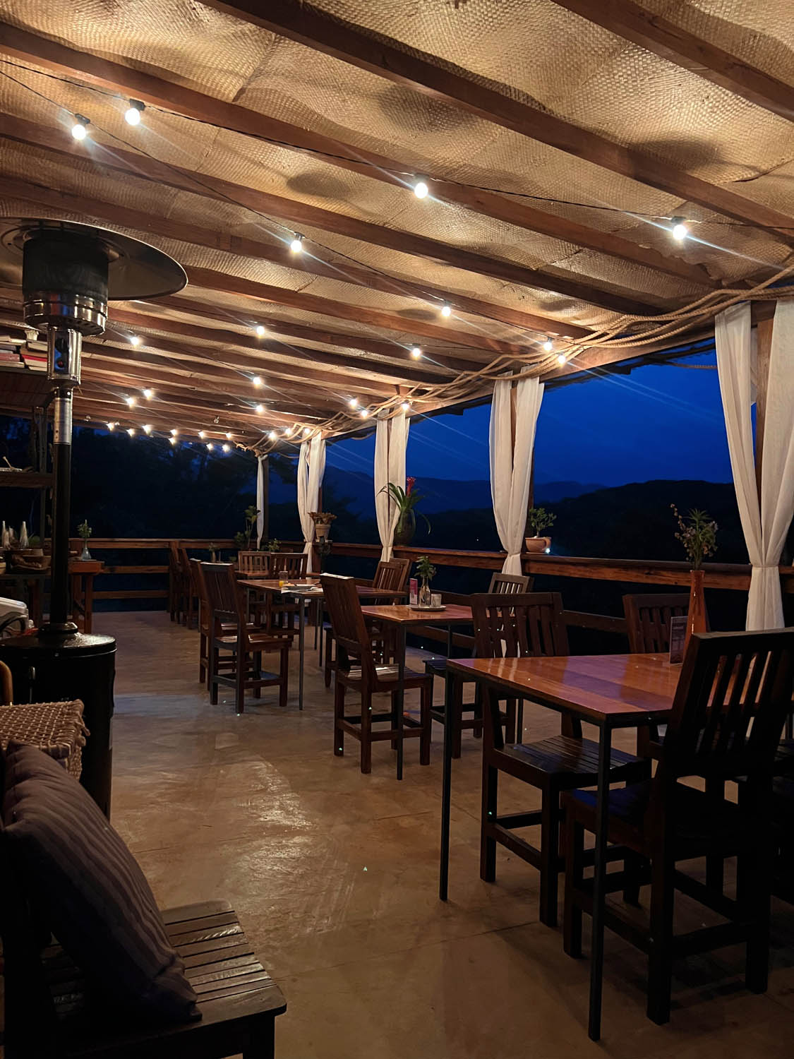 Restaurant veranda lit up at night with mountain views